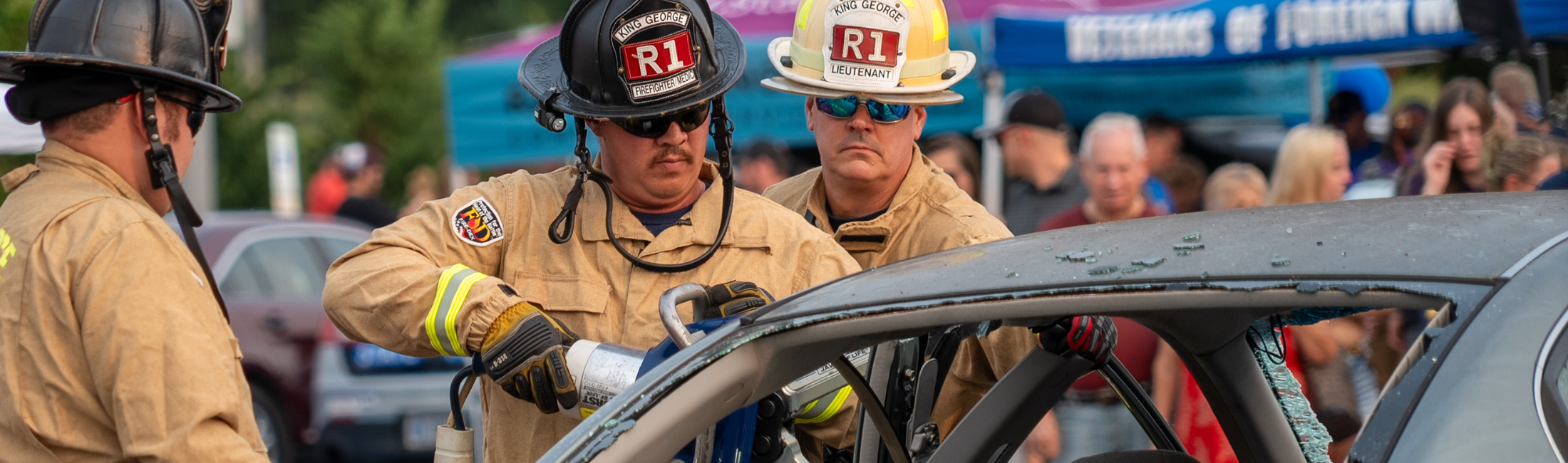 Firefighters demonstrating opening a jammed car door in an emergency