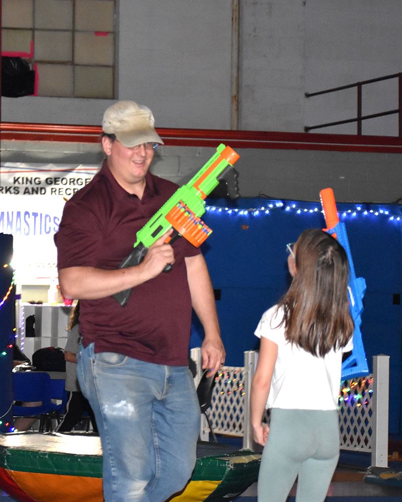 A father and daughter with their nerf blasters during a battle.